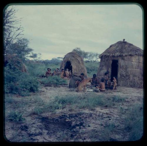 Two groups of people sitting, with skerms in the background