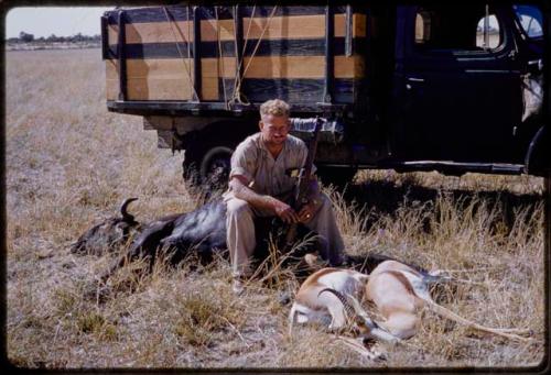 Theunis Berger sitting on a dead animal with another hunting kill in front