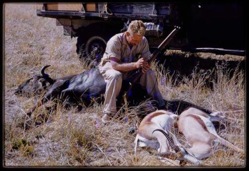 Theunis Berger sitting on a dead animal with another hunting kill in front