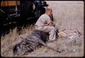 Theunis Berger sitting on a dead animal with another hunting kill in front