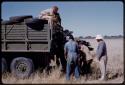 Expedition members hoisting a wildebeest into a truck