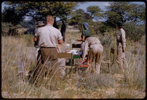 Marshall Expedition members, including John Marshall, Elizabeth Marshall Thomas, Lorna Marshall, Daniel Blitz, and L. F. Maingard eating lunch