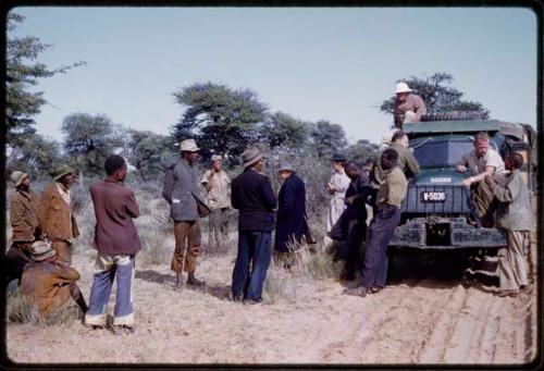 Group of men talking to Expedition members by a truck on the road