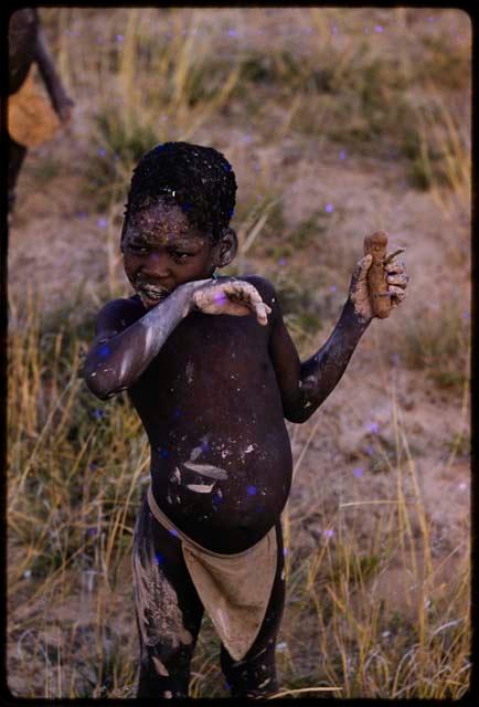 Child holding a clay horse he made