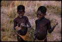 Two boys holding clay horses