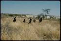 Walking: Group of women walking toward a waterhole, with a pan filled with water in the background