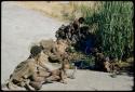 Water: !U sitting with !Ungka Norna and other women and children at the Gautscha waterhole, with !Ungka leaning over the water