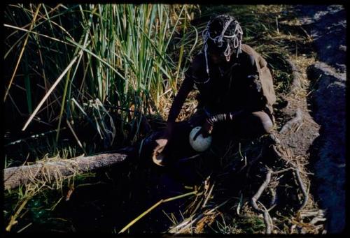 Water: Woman filling an ostrich eggshell with water