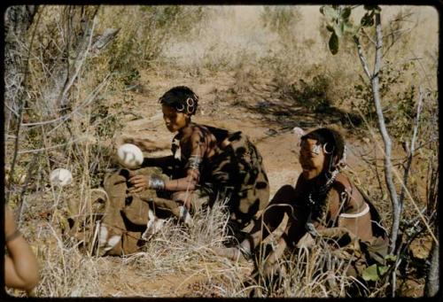 Water: Women sitting in the shade and putting ostrich egg shells into a kaross