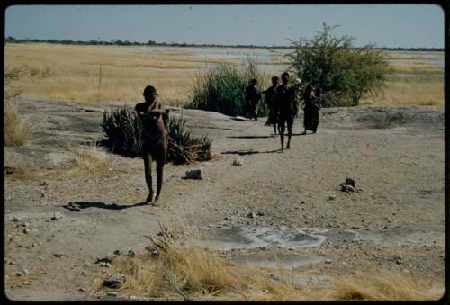 Water: People walking away from a waterhole, with Gautscha Pan in the distance