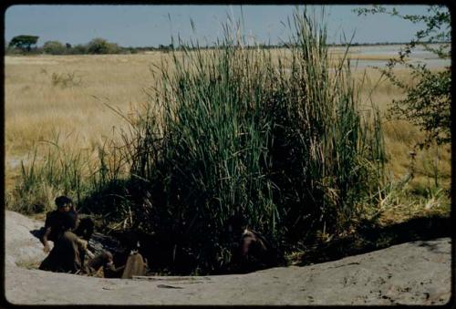 Water Hole: Group of women sitting at a waterhole, with Gautscha Pan in the distance