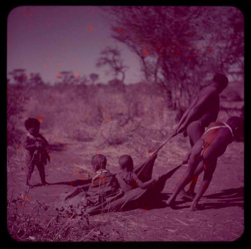 Children, Toys, Playthings: Two boys pulling two children on a kaross, with another child standing near them