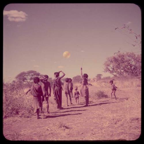 Children, Toys, Playthings: Girls playing with a yellow balloon given to them by Anneliese Scherz, tossing it in the air