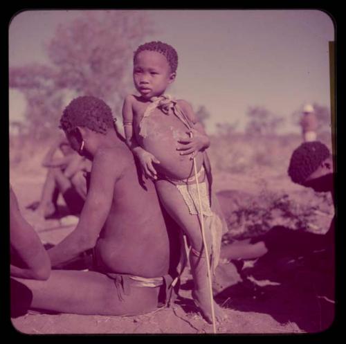 Children, "Fathers and Sons (Boys)": Be wearing an ostrich eggshell beaded apron, leaning against her father, Bo