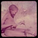 Children, Toys, Playthings: ≠Toma (Gau's son) making a slingshot from an old tube given to him by the expedition mechanic