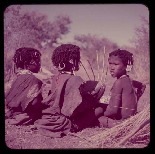 Children, Music: Three girls sitting, one playing a //guashi, view from behind