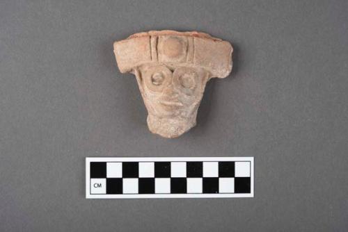 Large pottery head with circles around eyes