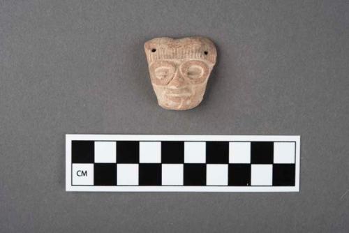 Potttery figurine head- perforations at corners and circles around eyes