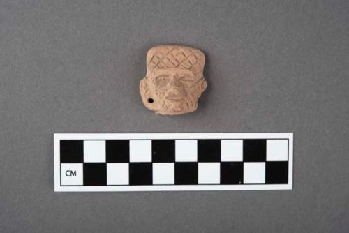 9 pottery figurine heads with incised lines on faces.