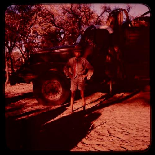 Tsamgao wearing Western clothes, standing by a truck