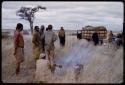 People standing around a fire near Expedition truck