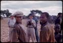 Group of people standing, Lorna Marshall standing behind with a camera