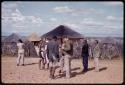 William Donnellan and Wilhelm Camm standing with other people, Lorna Marshall taking a picture of the village