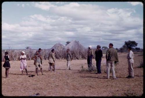 Expedition members and village members standing in field