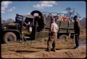 Expedition GMC truck on the side of a road, William Donnellan in the cab and expedition members standing by a puddle