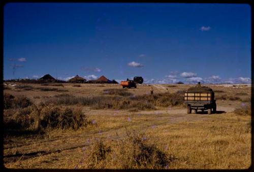 Expedition trucks driving up to a trader, seen from behind