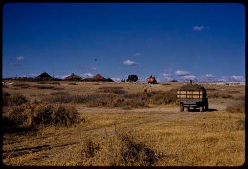 Expedition trucks driving up to a trader, seen from behind