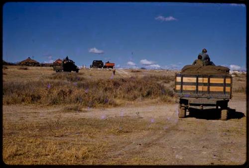 Expedition trucks driving up to a trader, seen from behind