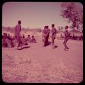 Dance: Men dancing in a line around a group of women sitting, view from behind