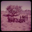 Dance: Men dancing in two lines around a circle of women sitting, view from the top of an expedition truck