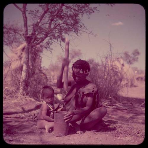 Food, Pounding: !Ungka pounding something in her mortar, with Sa≠gai sitting next to her