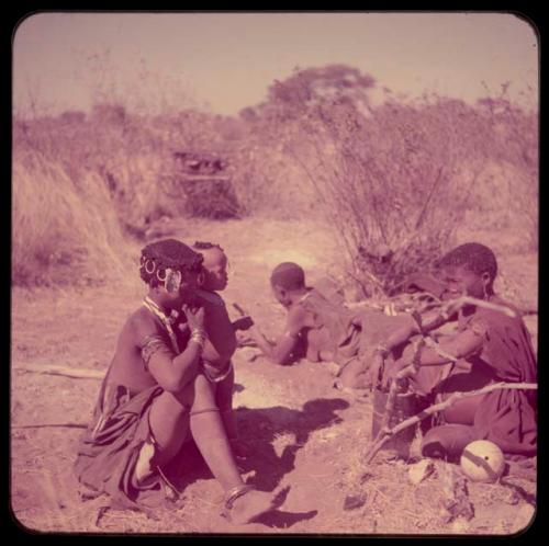 Groups, Extended Family: Khwo//o (mother of "Gao Medicine") lying down, with her daughter, /Goishay (wife of ≠Gao, headman of Band 3) and other women sitting next to her