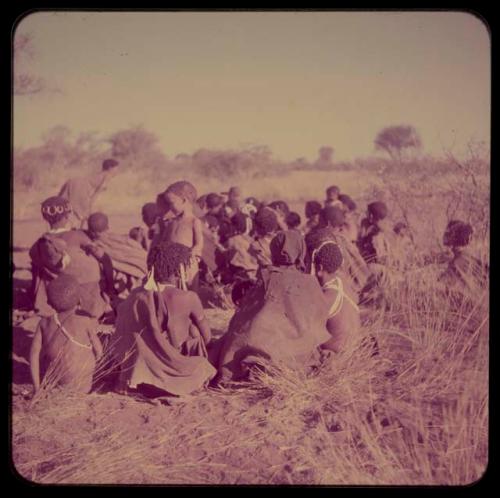 Groups, Extended Family: Group of women sitting, gathered to sing for a recording of dance songs, view from behind