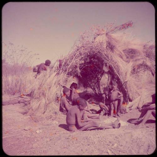 Groups, "Nuclear Family": Part of Gau's family sitting in front of a skerm, with Be leaning against the skerm