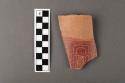 Tan and red incised rim potsherd.