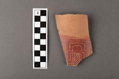 Tan and red incised rim potsherd.