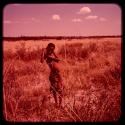 Boy standing, leaning on a digging stick to gather food