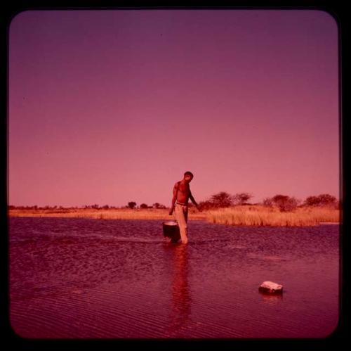 /Ti!kay walking in pan, carrying a bucket