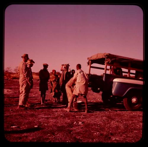 /Ti!kay's family gathered near the back of Father Jean Marie's truck on "Boer War Memorial Day"