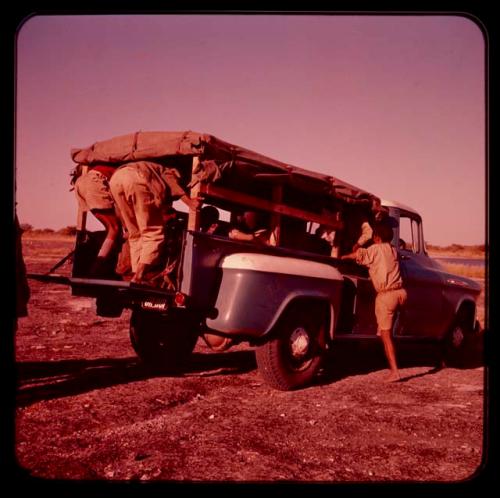 /Ti!kay's family getting in Father Jean Marie's truck on "Boer War Memorial Day"