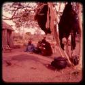 Group of people sitting in front of a hut