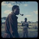 Man with a pipe in his mouth and another man standing in the background at Venter’s (Fendare) property