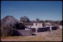 House with a walled fence, people out front