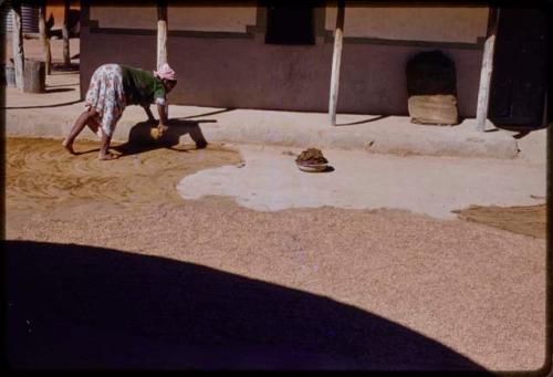 Woman bent over, making dung floor