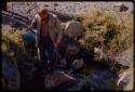 Theunis Berger getting water with a bucket at a waterhole