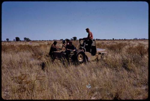 John Marshall taking a photo, Elizabeth Marshall Thomas and Theunis Berger sitting in the expedition Jeep